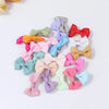 A collection of colorful pet hair clips in various shades including pink, green, purple, and red.