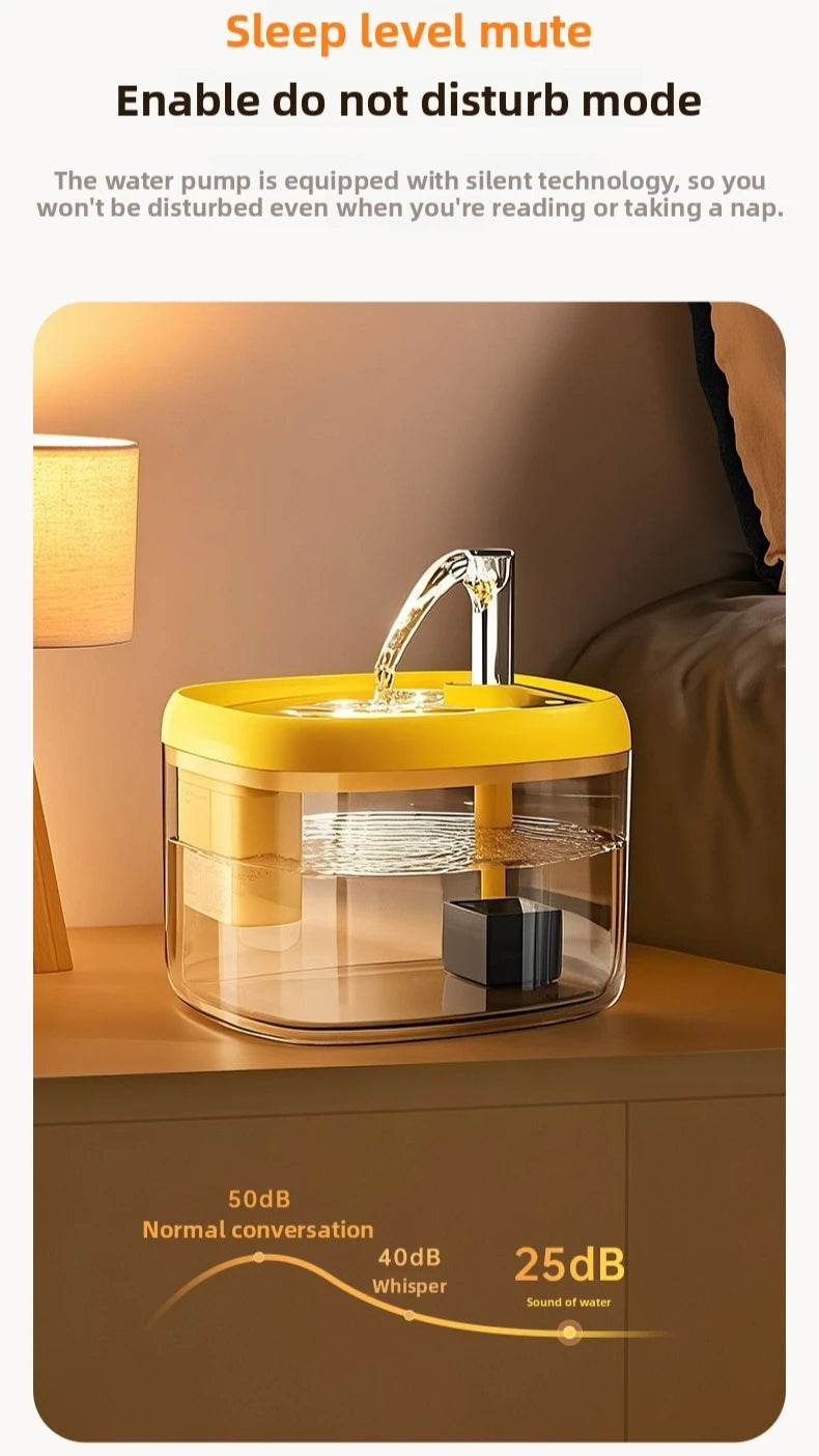Fontaine à eau automatique jaune avec un bol en verre sur une surface en bois.
