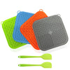 A set of silicone licking mats for dogs and cats in green, blue, orange, and gray, with two yellow-green spoons.