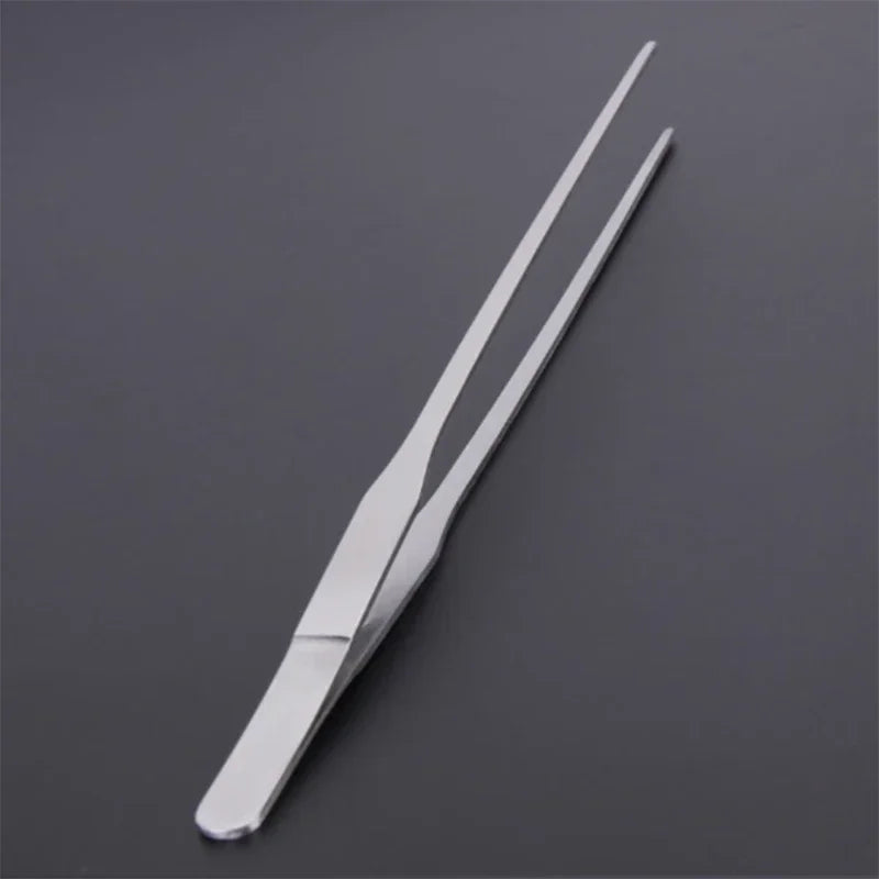 Stainless steel aquarium cleaning tweezers shown diagonally on a dark gray surface.