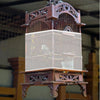 A vintage wooden bird cage with a clear plastic seed guard net and decorative metalwork.
