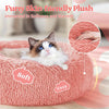 Flauschiges rosa Plüschbett mit einer dösenden Katze, das weich und warm hervorhebt.