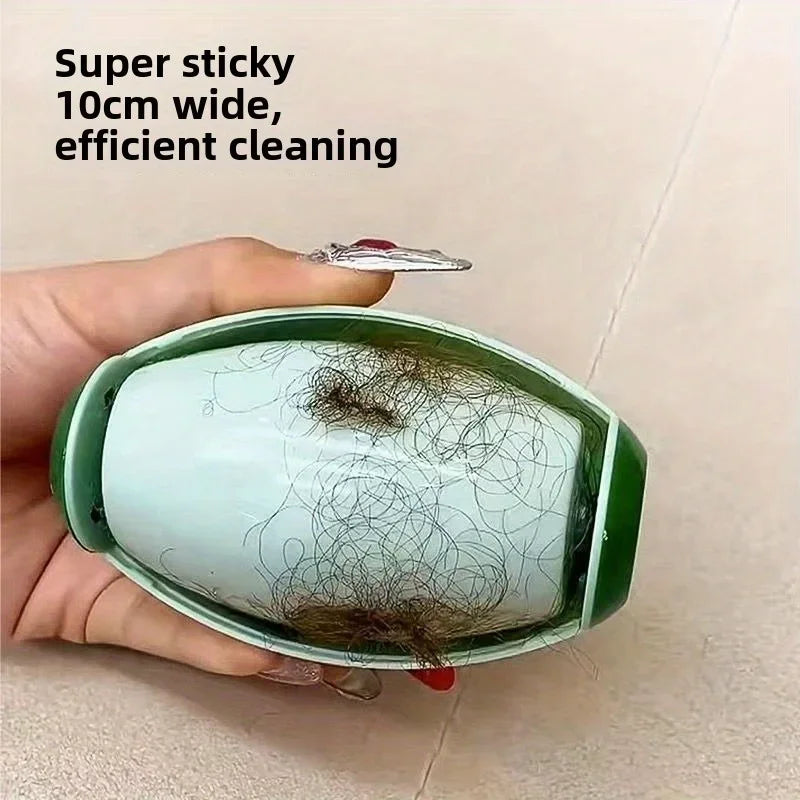 A hand holds a green reusable lint roller with a silver roller, demonstrating its use for cleaning.