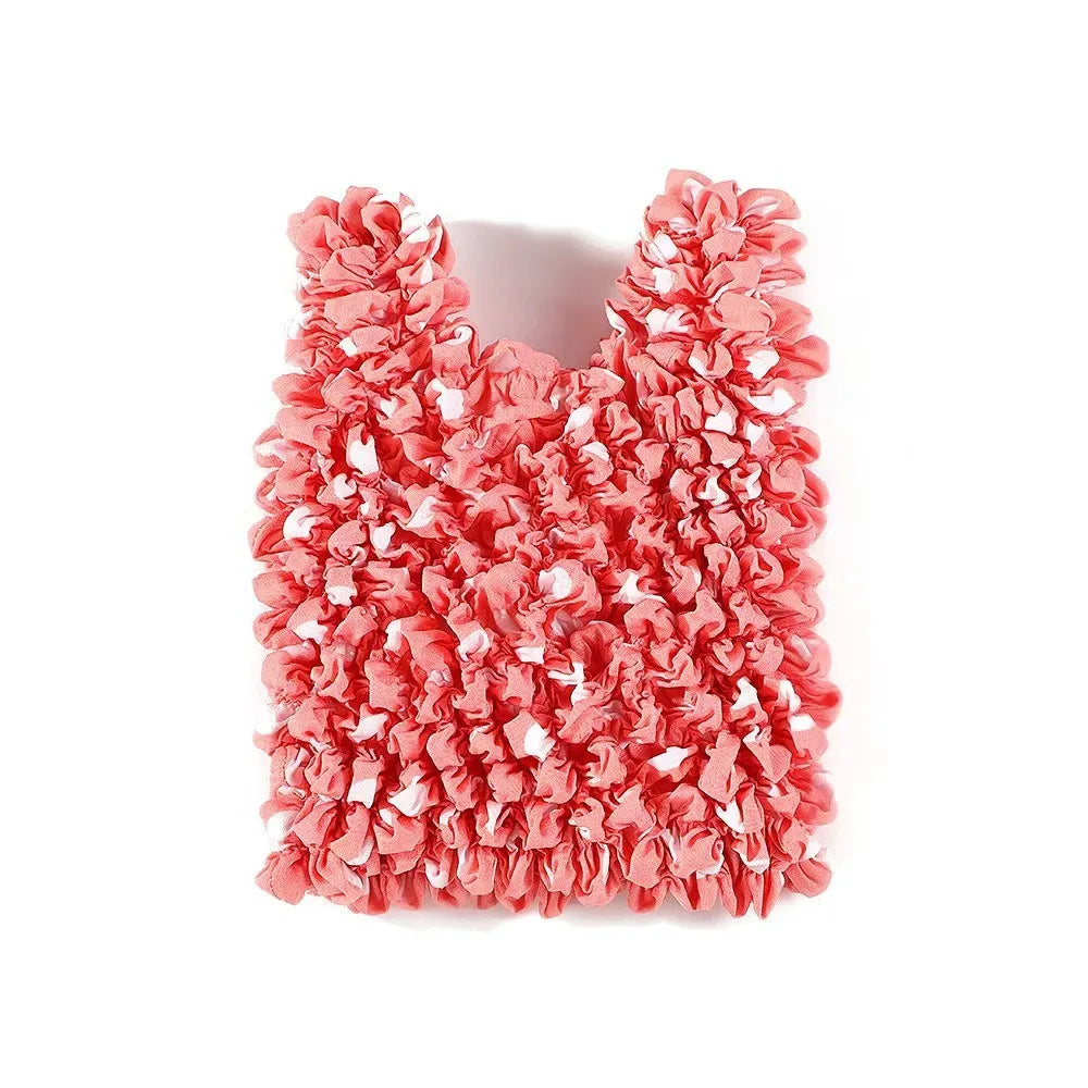 A close-up of a reusable foldable bubble shopping bag made of ruffled pink fabric.