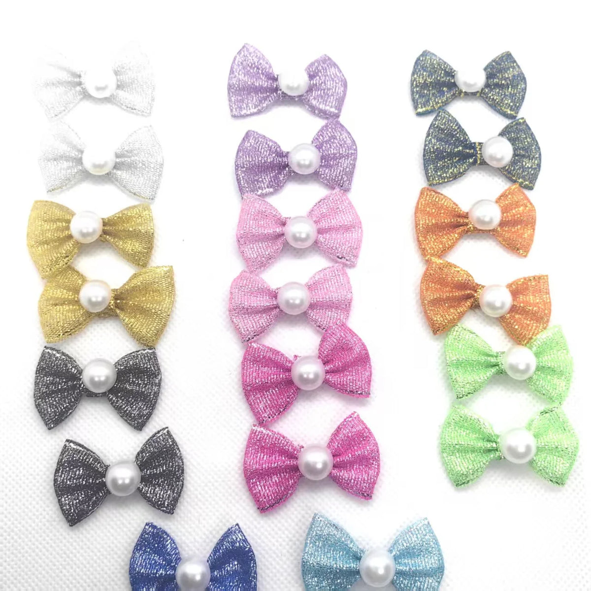 Eine Sammlung farbenfroher Hundebändelknoten für das Tierpflegegrooming in Lila, Pink, Gold und Grau.