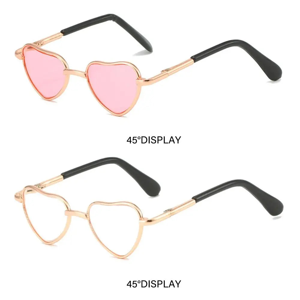 Pink heart-shaped sunglasses with gold and black frames for pets