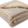 A rolled-up beige microfiber blanket with a fluffy trim, showing its soft texture.