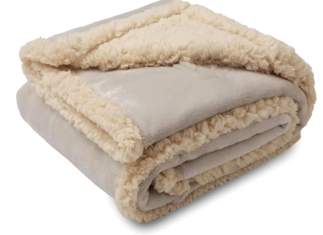 A rolled-up beige microfiber blanket with a fluffy trim, showing its soft texture.
