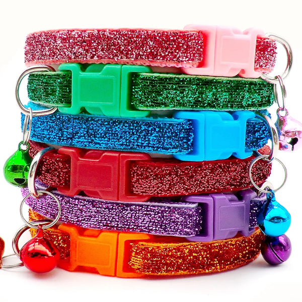 Ein Stapel bunter, glitzernder Halsbänder für Haustiere in verschiedenen Farben wie rosa, grün, blau, lila und orange.