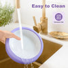 A purple bowl with a slow feeder insert is being rinsed under a faucet for easy cleaning.