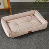A beige corduroy pet sofa bed for dogs and cats lying on a gray carpet.