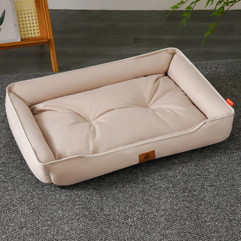 A beige corduroy pet sofa bed for dogs and cats lying on a gray carpet.
