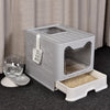 A gray foldable cat litter box with a front entry and top exit is shown on a dark surface.