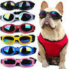 A collection of colorful collapsible dog sunglasses for pets with adjustable straps.
