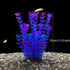 Un amas de plantes aquatiques artificielles violettes dans du gravier avec un petit poisson jaune.