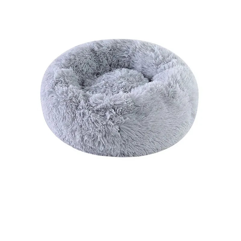 A round, plush faux fur bed for cats and dogs in a light gray color.