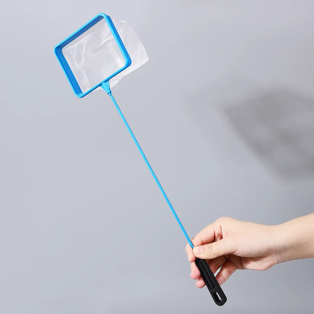 A hand holds a blue mesh aquarium fish net with a long handle against a light gray background.