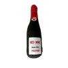 A black bottle-shaped squeaky plush dog toy with a red tip and white paw print detail.