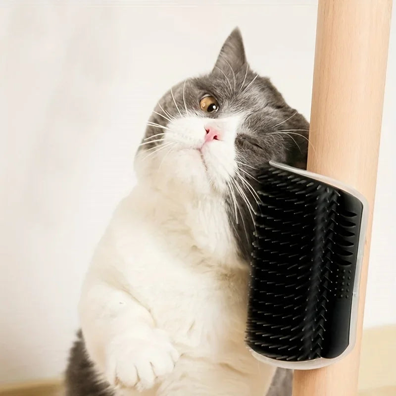 A gray and white cat is grooming itself using a wall-mounted massage comb.