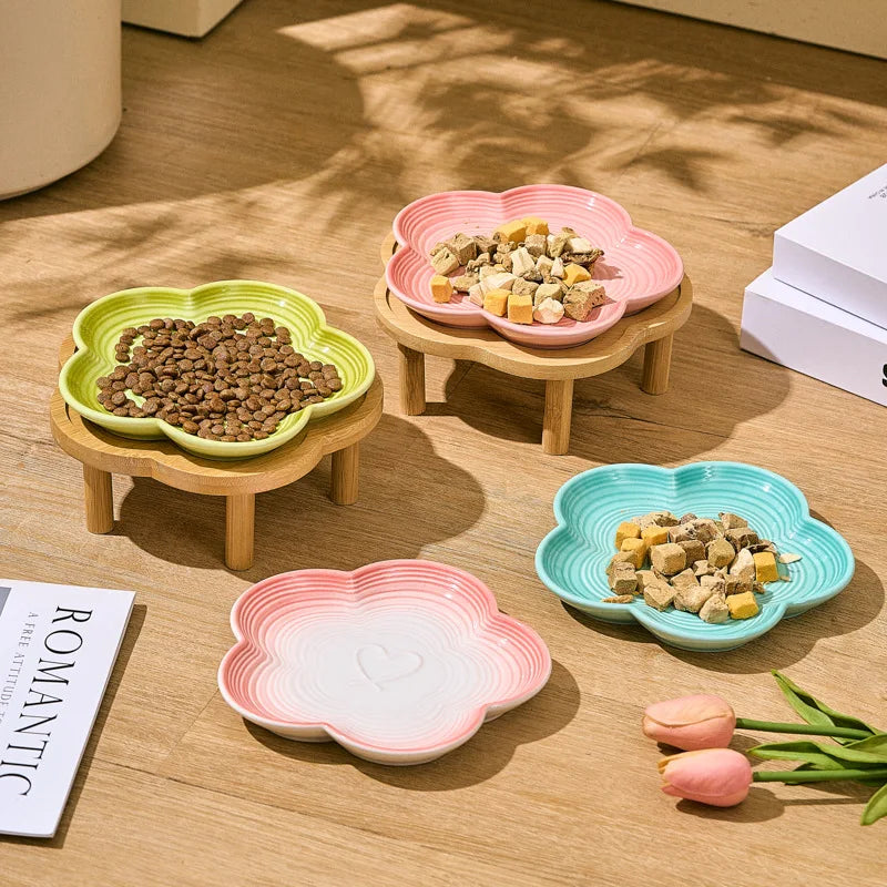 Un ensemble de bols à animaux en céramique esthétiques roses et verts, présentés sur un support en bois.