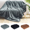 A fluffy gray microfiber blanket draped over a sofa, shown alongside folded versions.