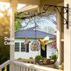 Decorative hanging metal bird feeder with a yellow and orange bird is suspended from an outdoor bracket.