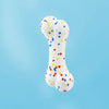 A white, bone-shaped chew ball for dogs, speckled with colorful confetti.
