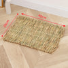 A rectangular mat woven from natural straw placed on a light wooden floor.