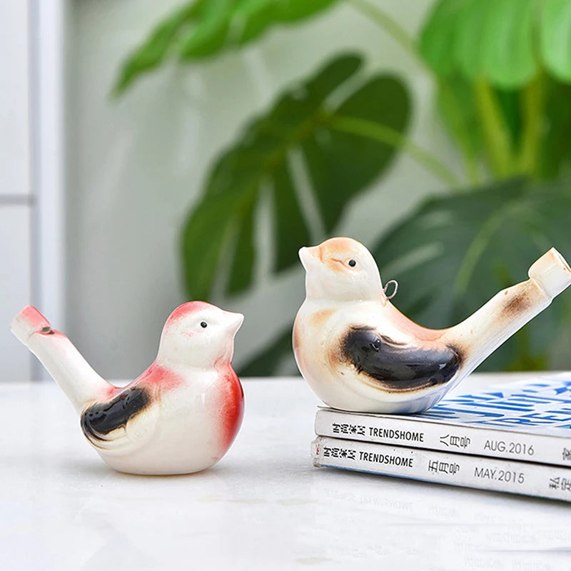 Keramisches Wasservogel-Signalhorn in Weiß und rötlich-orange Farben auf einem Stapel Bücher.
