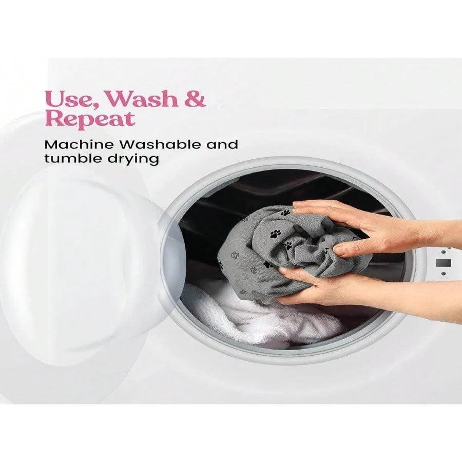 Hands are placing a gray reusable dog urine pad into the drum of a washing machine for cleaning.
