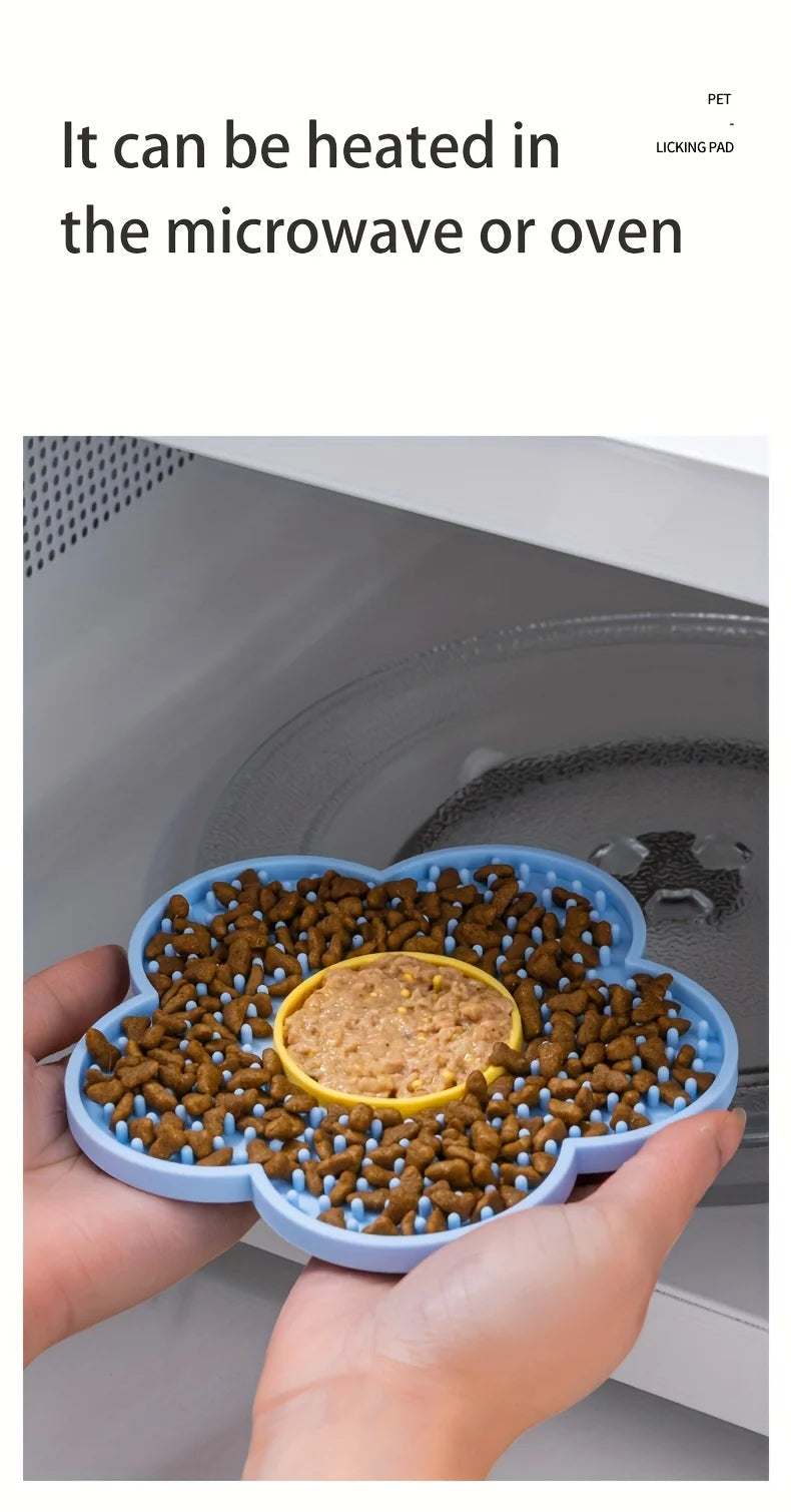 A hand holds a silicone lick mat filled with brown pet food, ready to be heated in an oven or microwave.