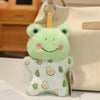 A soft, light green cartoon frog bean bag plush toy with pink accents is displayed next to a beige bag.