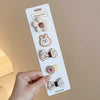 A white card displaying five handmade flower-shaped baby hair clips in various textures and colors.
