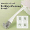 Brosse nettoyante multifonctionnelle blanche pour cage d'animal avec tête à poils, à côté d'une cage.