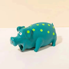 A teal plastic pig toy with bright green polka dots, shown from the side.