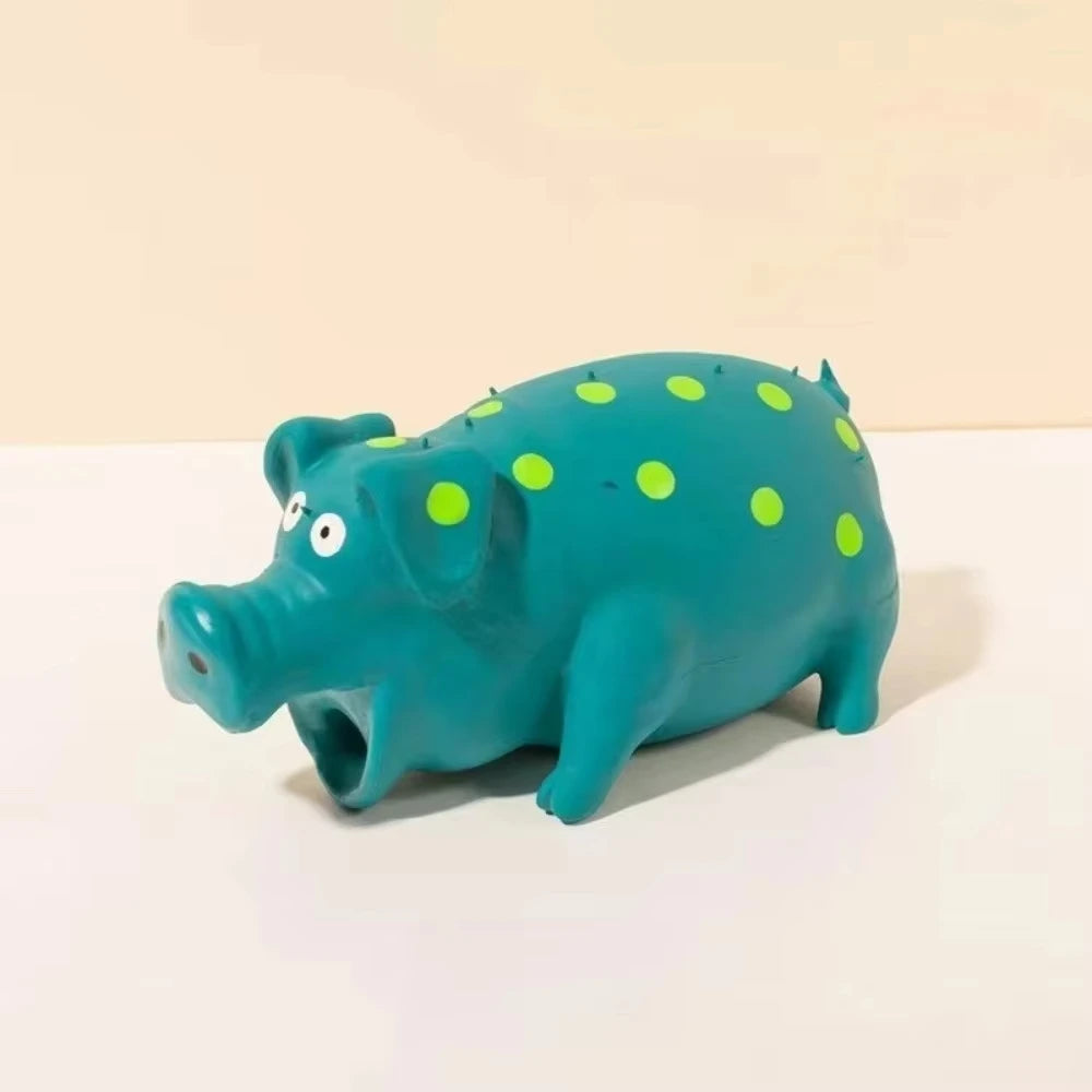 A teal plastic pig toy with bright green polka dots, shown from the side.