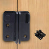 A black sliding bolt lock mechanism mounted on a light wood surface.