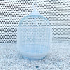Clear breathable nylon mesh bird cage seed guard with a dome top resting on white gravel.