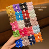 Verschiedene bunte Stoffhaarspangen und -clips in verschiedenen Pink-, Blau-, Gelb-, Grün- und Schwarztönen.