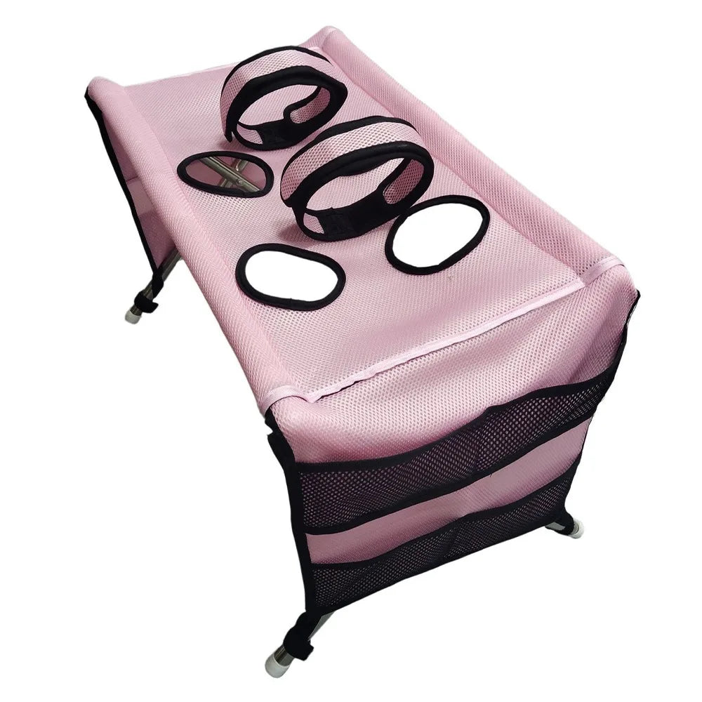 Pink foldable pet grooming hammock with a mesh lining and black trim for bathing and nail trimming
