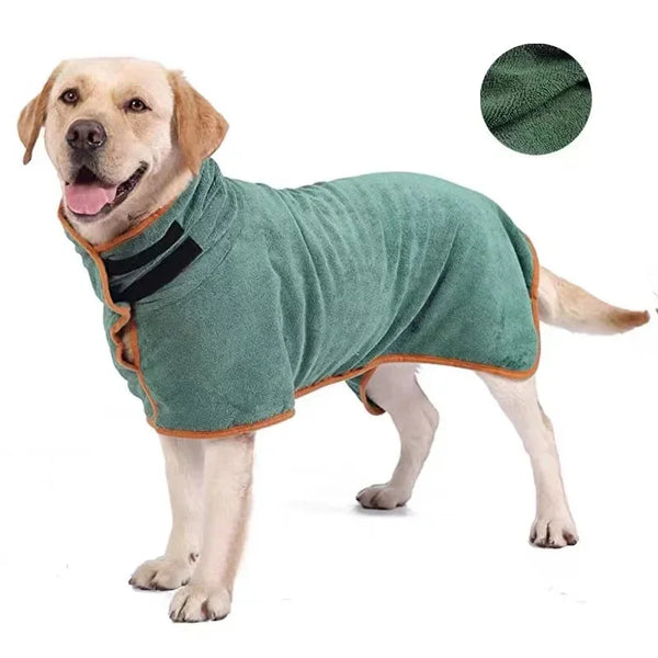 A light-colored dog wearing a green absorbent quick-dry pet bathrobe wrap with black trim.