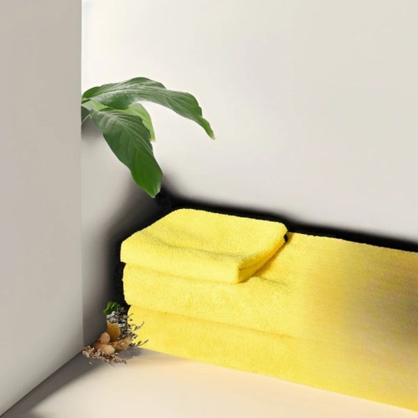 Une pile de serviettes de bain pour animaux jaunes vives et ultra-absorbantes sur une surface blanche.