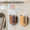 Wooden cat whisker collector vases with glass tubes and a small figurine on a white cabinet