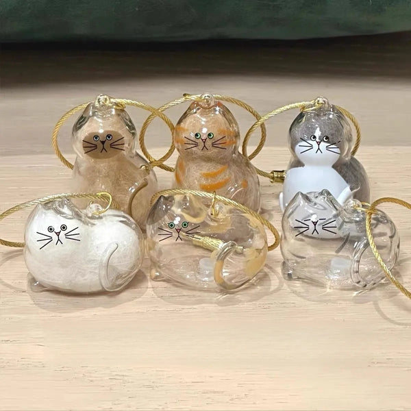 A collection of ginger and gray cat-shaped hair storage keychains for pets, featuring various textures and clear resin.