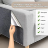 A hand is peeling back a corner of a gray fabric surface to remove a sticking pad protector.