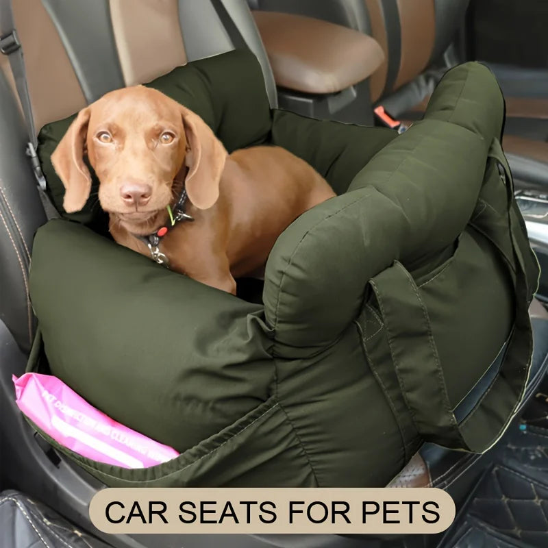 A light brown dog is resting inside a green pet car seat in a vehicle.