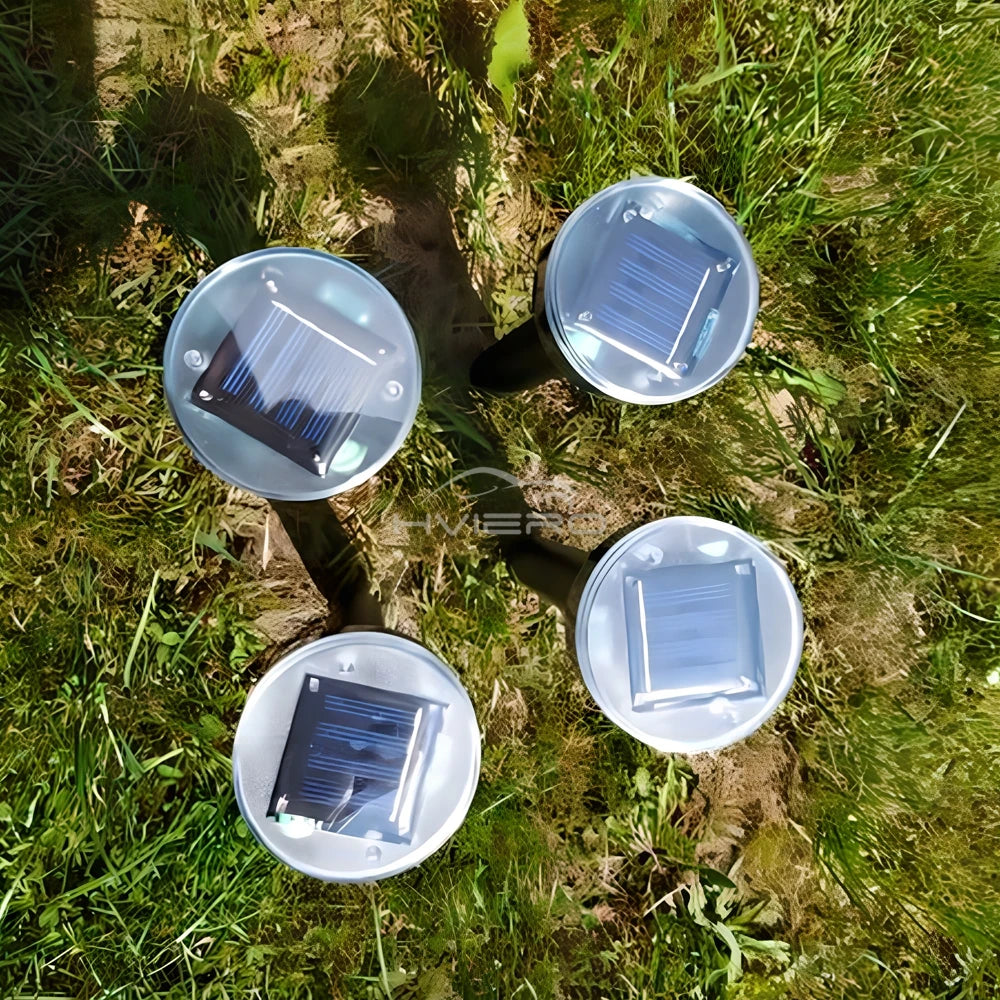 Three clear ultrasonic pest repellers are placed on green grass with sunlight filtering through.