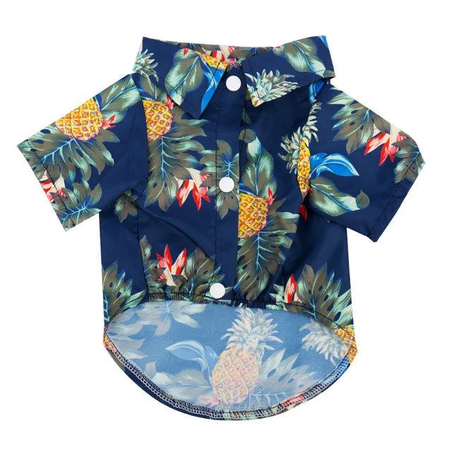 A dark blue short-sleeved shirt with a tropical pineapple and leaf print for a dog.
