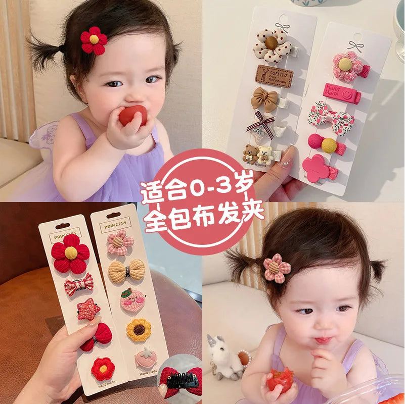 A set of five adorable flower-shaped baby hair clips in various colors and patterns for infants