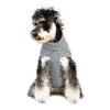 Un pull pour chiot noir et blanc moelleux, tricoté en laine grise.